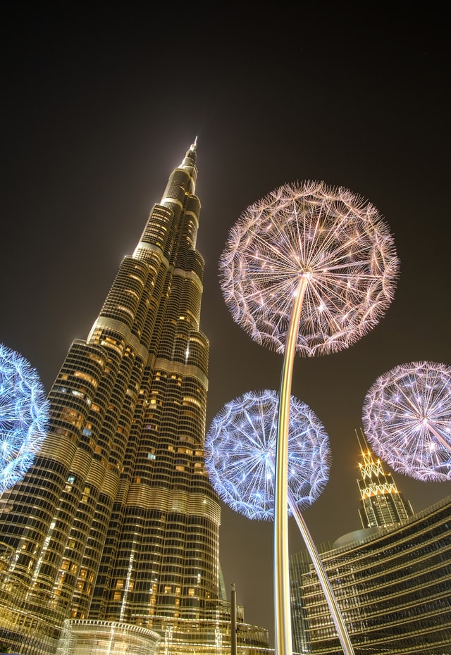 Low-angle photograph of the Burj Khalifa, Dubai, United Arab Emirates lit up with dandelion-style light installations. 