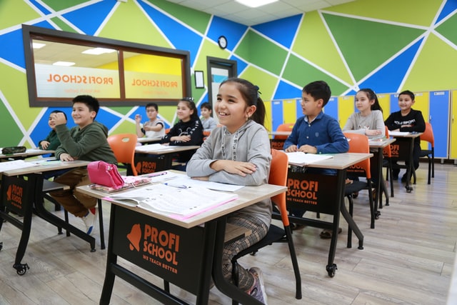 Group of children sitting at desks in a classroom.