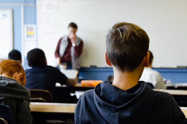 children in classroom listening to teacher