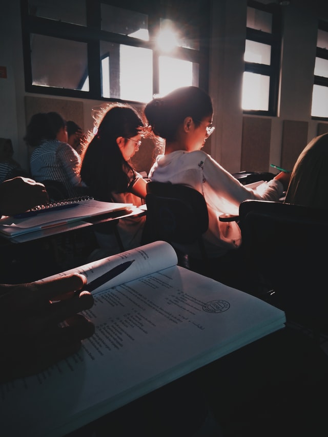 Students in classroom. Camera facing student in a white sweater