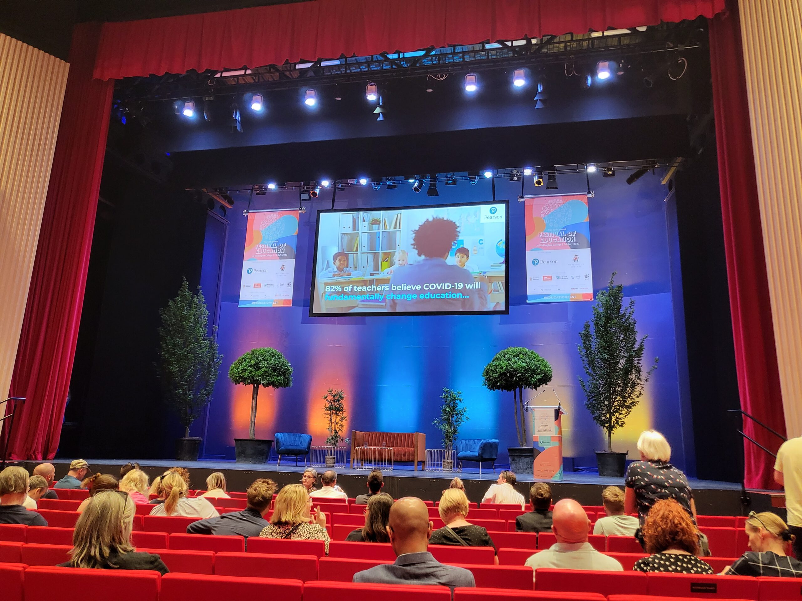 A group of people watch a presentation at a conference