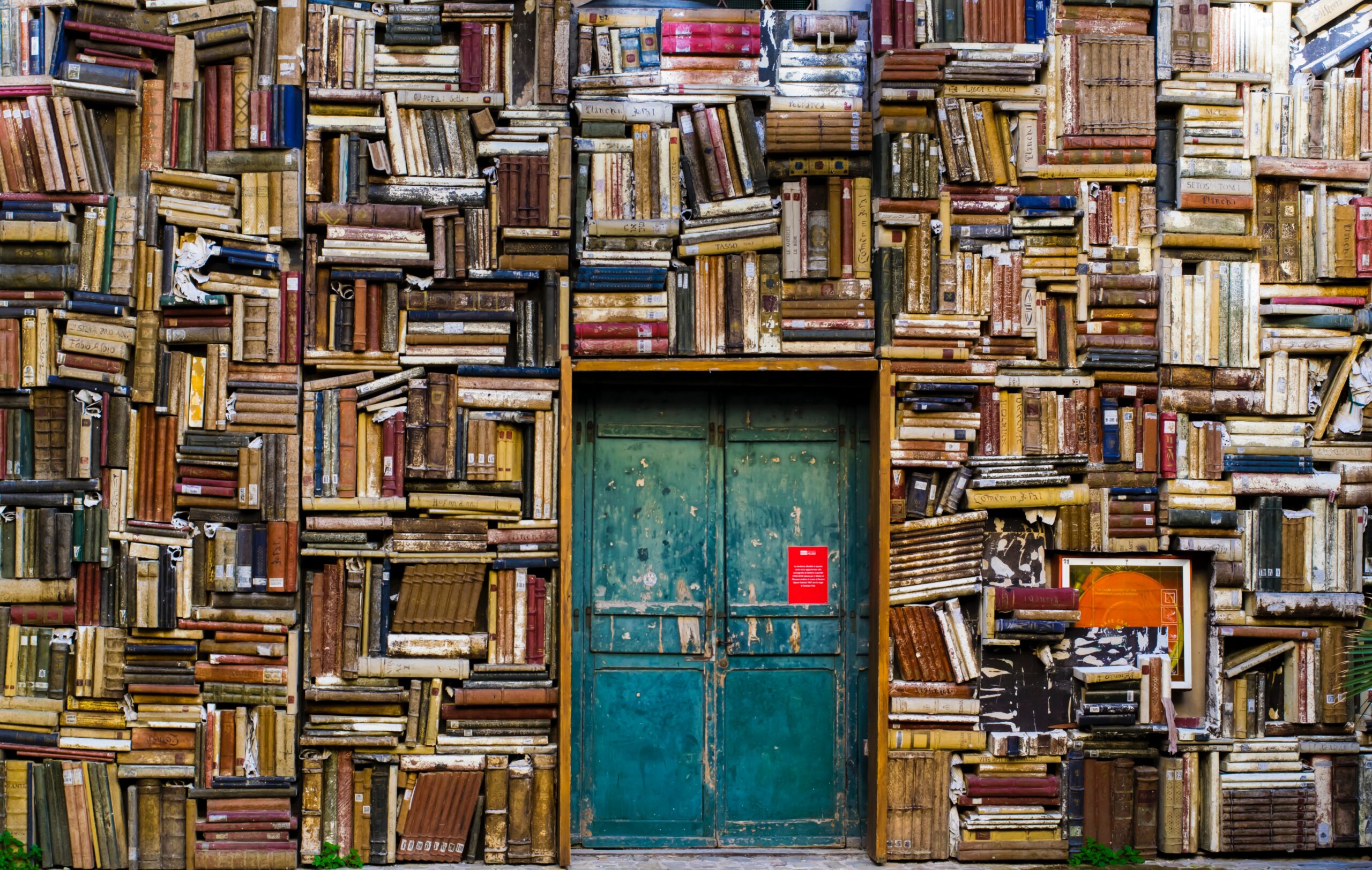 Books surrounding perimeter of a blue metal door