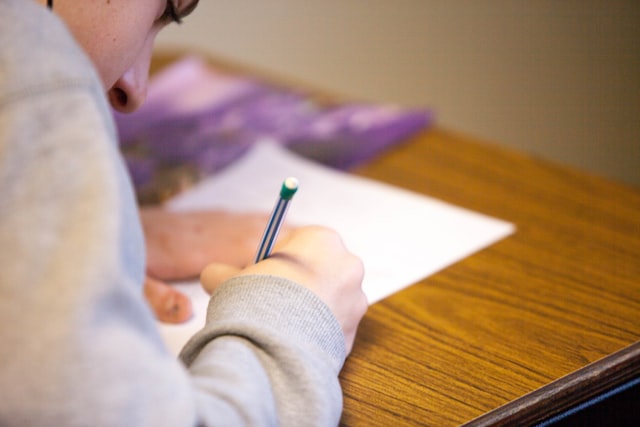 Student writing on a test paper.