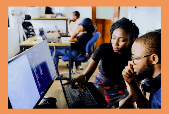 Woman and man sitting looking at a computer screen.